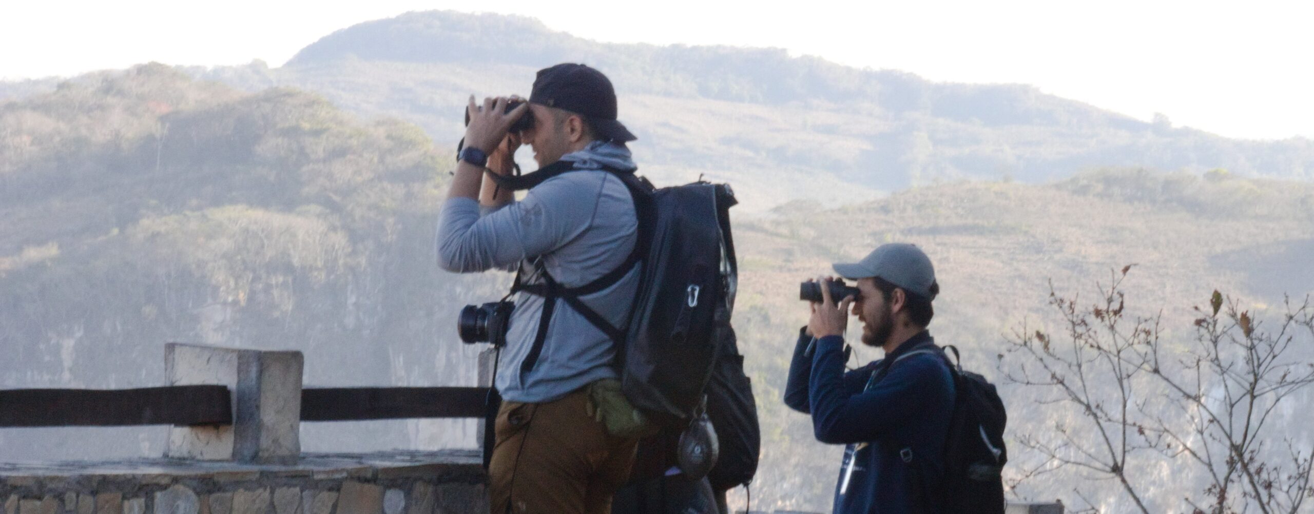 Two birdwatchers at Sumidero Canyon Chiapas look through their binoculars with a mountain backdrop
